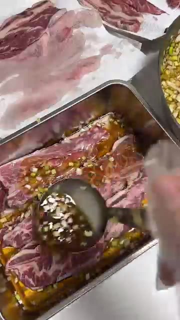 양념에 재운 LA갈비를 용기에 나눠 담습니다. — 넉넉하게 나눠 담는 LA갈비