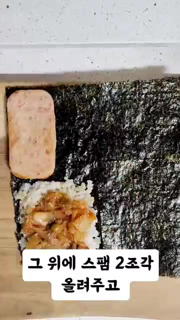 김치 위에 스팸 두 조각을 올리고, 그 옆에 치즈 한 장을 올린다. — 접어먹는 김밥 레시피