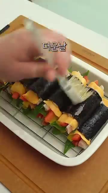 참기름과 통깨를 뿌려 마무리하면 불 없이 만드는 김밥 완성입니다. — 불 안 써도 맛있는 집김밥