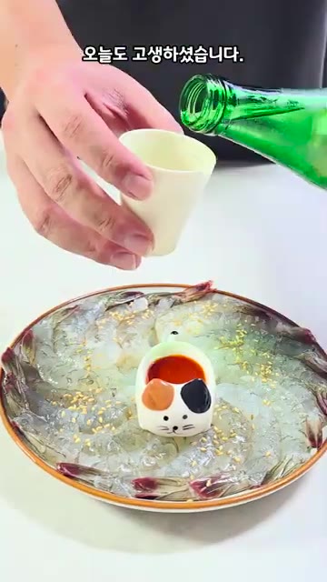 고양이 모양 그릇에 초장을 담고 청하를 따라줍니다. — 생새우회: 껍질 까서 초장 찍어 먹기