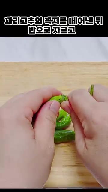 꽈리고추의 꼭지를 떼어낸 뒤 반으로 자른다. — 꽈리고추 어묵볶음