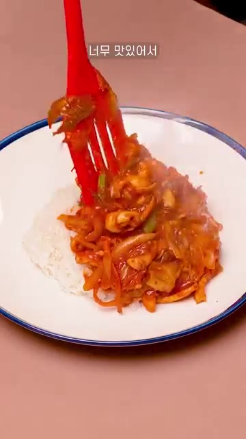 완성된 오징어덮밥을 밥 위에 올리고 깨를 뿌려준다. — 매콤달콤한 오징어 덮밥 레시피!