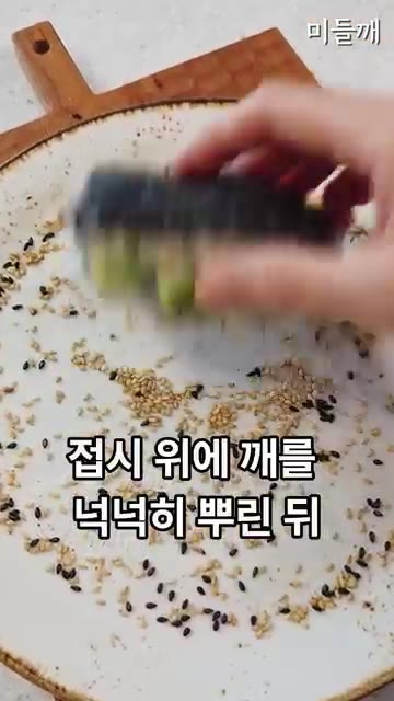 접시 위에 참깨를 넉넉히 뿌리고 김밥을 올려 앞뒤로 굴려가며 참깨를… — 김밥을 노릇하게 구웠더니? 사 먹는 것보다 10배 맛있는 10분 초간단 새우김밥