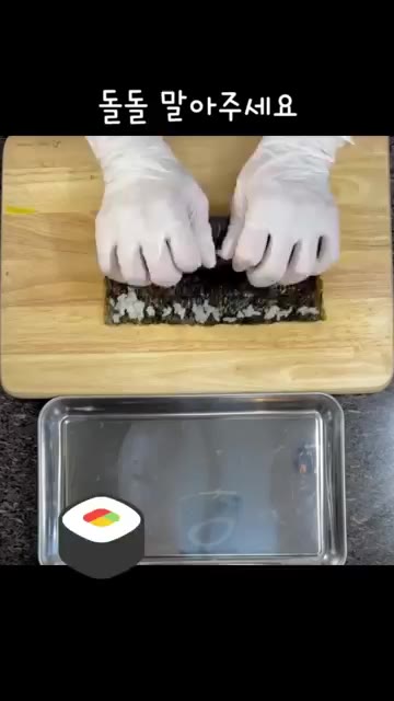 김밥을 돌돌 말아 참기름을 바르고 통깨를 뿌립니다. — 불 없이 만드는 초간단 오이 맛살 김밥