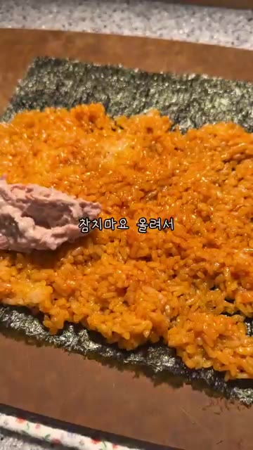 김 위에 불닭 소스와 참기름을 섞은 밥을 얇게 펼친다. — 초간단 불닭 참치김밥
