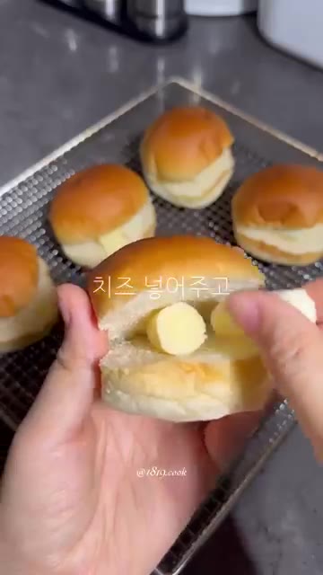 칼집 낸 모닝빵 안에 버터를 넣는다. 치즈를 넣는다. 모닝빵을 덮는다. — 모닝빵 소금빵 만들기