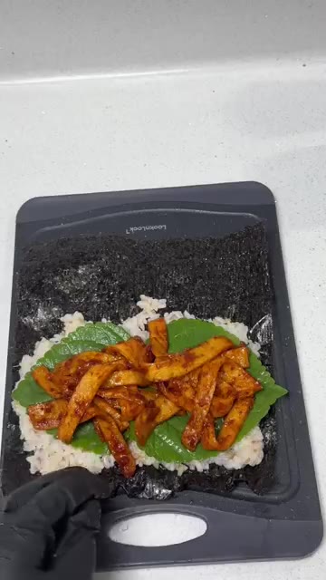 김밥 김 위에 밥을 얇게 펴고 깻잎을 올린 후, 볶은 어묵과 단무지… — 매콤달콤 중독적인 매콤어묵김밥