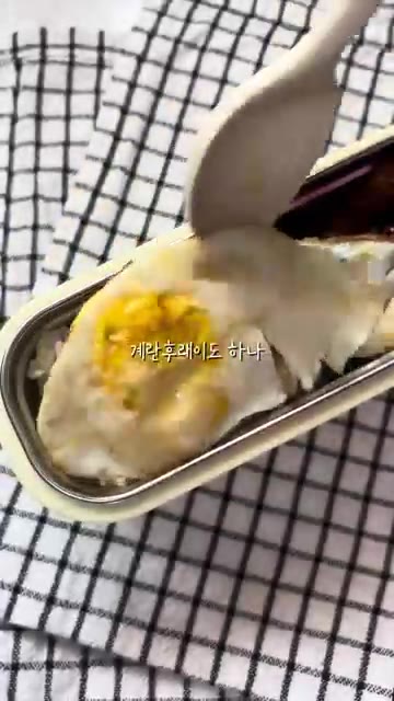 계란 프라이를 만들어 밥 위에 올린다. — 매콤 목살 도시락 만들기