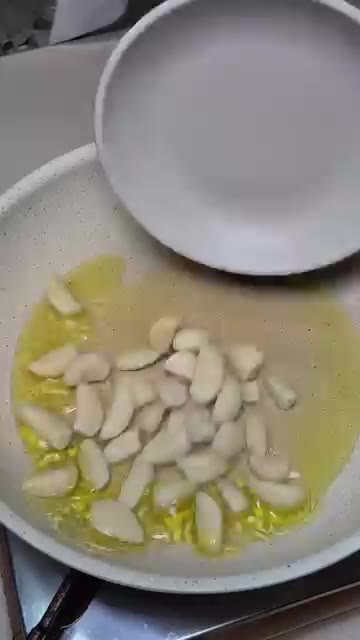 팬에 올리브오일을 넉넉히 두르고 편으로 썬 마늘을 넣고 볶는다. — 감바스 짜장라면 레시피