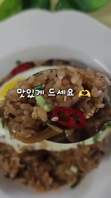그릇에 밥을 담고 계란 프라이, 쪽파, 통깨를 올려 마무리한다. — 찬밥으로 만드는 가지솥밥