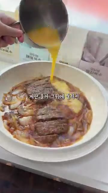 뚜껑을 덮고 약불로 계란을 익힌다. 마지막으로 참깨를 뿌려 완성한다. — 돈까스보다 더 맛있다는 떡갈비덮밥 한그릇요리