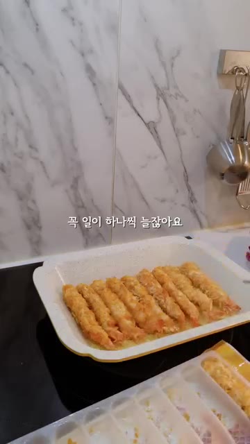 튀겨낸 새우튀김을 키친타월에 올려 기름기를 제거한다. — 새우튀김김밥과 새우튀김우동