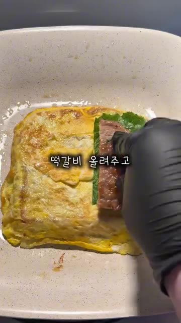 계란이 익으면 뒤집어주고 한쪽에 치즈, 상추, 떡갈비를 올린다. — 요즘 토스트는 이렇게 먹는다는데! 떡갈비 토스트