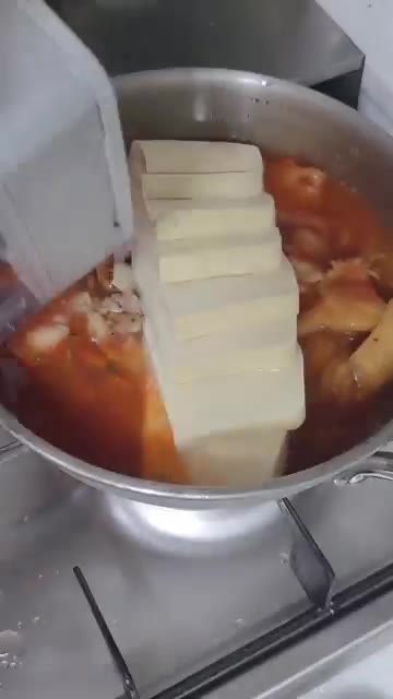 끓고 있는 김치 국물을 두부 위에 부어준다. — 두부김치찜 만들기