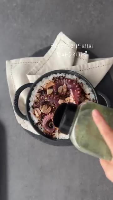크러쉬드 레드페퍼와 파슬리 가루를 뿌려 마무리한다. — 문어를 통으로 올려 푸짐하게 #시오콘부문어솥밥