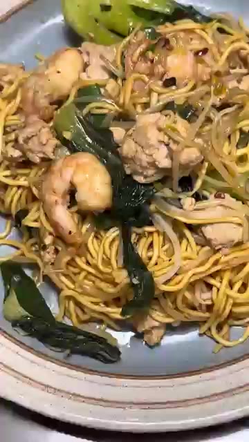 완성된 볶음면을 접시에 담아 맛있게 먹는다. — 홍콩식 에그누들 볶음면