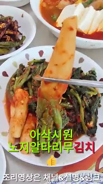 집게로 노지 알타리무김치를 집어 먹기 좋게 보여준다. — 26년 가을 집밥일기: 두부찌개, 알타리무김치, 쪽파김치, 국물장조림, 멸치볶음 등