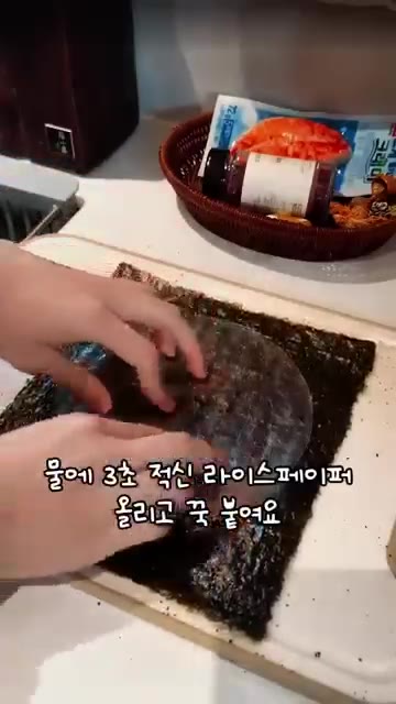 김의 매끈한 면에 쯔란 고춧가루를 뿌리고, 물에 3초간 적신 라이스… — 김 위에 크래미를 올려 구워 만드는 한입 안주