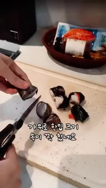 말아진 김을 가위로 한입 크기로 잘라 트레이에 펼쳐 놓습니다. — 김 위에 크래미를 올려 구워 만드는 한입 안주