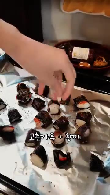 고춧가루와 흰깨를 뿌리고 겉면에 식용유를 뿌려줍니다. — 김 위에 크래미를 올려 구워 만드는 한입 안주