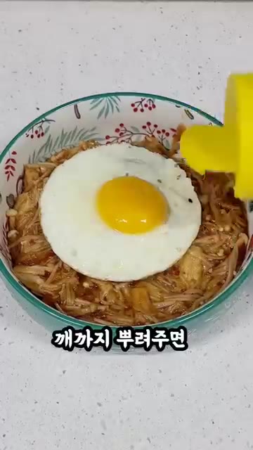 계란 후라이를 올리고 참깨를 뿌려 완성한다. — 진짜 식감 미친 팽이버섯 덮밥 완성!