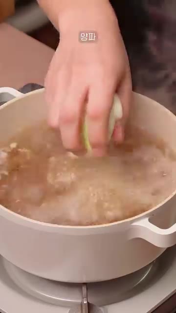 물이 끓어오르면 다진 마늘 1큰술, 썰어둔 양파, 무, 대파를 넣는다. — 간편한 소고기 무국 레시피