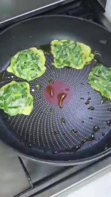 반죽 위에 찢어 놓은 크래미를 올리고 앞뒤로 노릇하게 부친다. — 크래미부추전