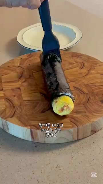 참기름을 바르고 깨소금을 뿌린 후 먹기 좋게 잘라줍니다. — 간단 계란말이 김밥 레시피