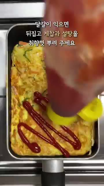 달걀이 익으면 뒤집고 케첩과 설탕을 취향껏 뿌려줍니다. — 양배추 계란 토스트 (길거리 토스트)