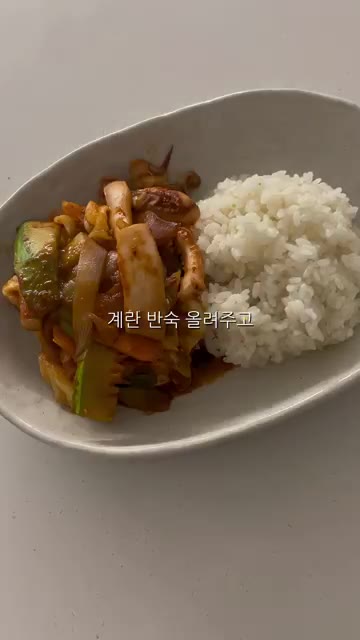 밥 위에 오징어볶음을 올리고 계란 프라이를 얹어줍니다. — 야채 냉털 오징어볶음