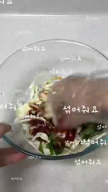 깻잎 10장 정도를 돌돌 말아 얇게 썰어 양배추와 함께 볼에 담는다. — 새콤달콤 비빔만두 이렇게 해보세요