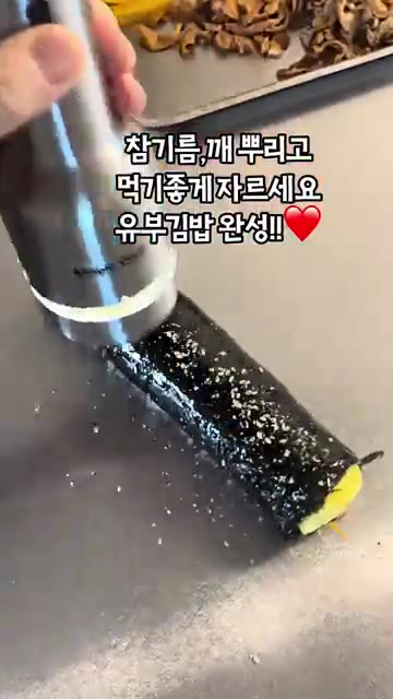 김밥 겉면에 참기름과 깨를 뿌리고 먹기 좋게 썰어 유부김밥을 완성합니다. — 유부김밥과 유부국수 만들기