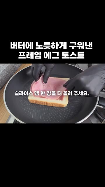 팬에 버터 한 조각을 넣고 녹인 후, 식빵 테두리를 팬에 올립니다. — 버터에 노릇하게 구워낸 프레임 에그 토스트