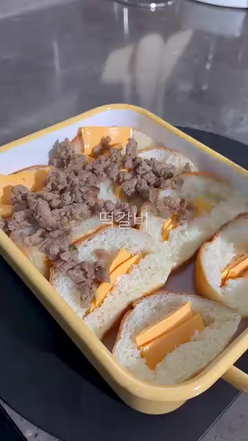 모짜렐라 치즈를 듬뿍 올리고 파슬리 가루를 뿌린다. — 모닝빵 떡갈비 치즈구이 레시피