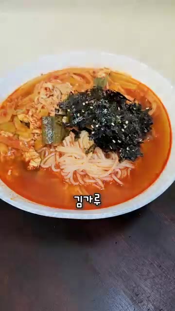 그릇에 면을 담고 육수를 부은 뒤 김가루와 후추를 뿌려 완성한다. — 얼큰 잔치국수