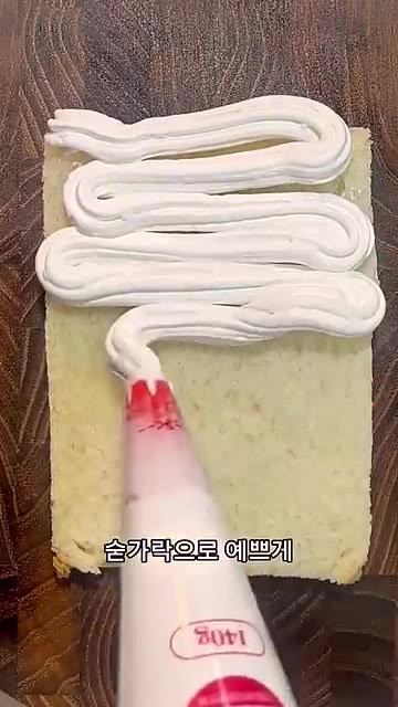 식빵 위에 생크림을 듬뿍 짜서 숟가락으로 예쁘게 펴 발라줍니다. — 귤산도 만들기