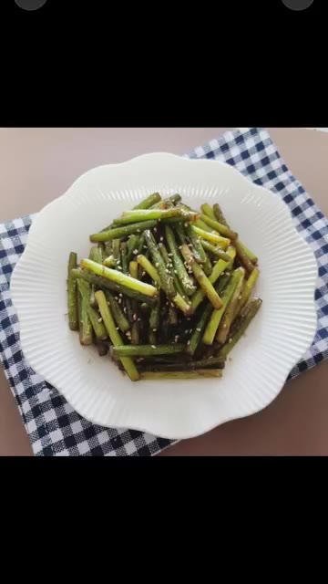 볶은 마늘쫑을 접시에 담아낸다. — 오늘의 추천 요리 마늘쫑 볶음