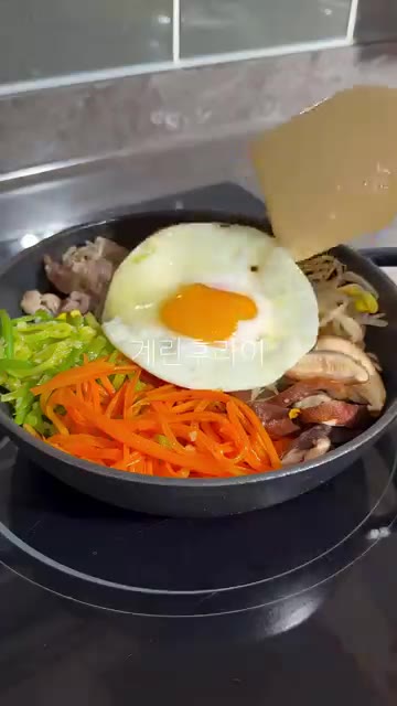 계란 후라이를 올리고 참기름을 뿌린다. — 전자레인지로 7분 완성! 초간단 비빔밥 레시피