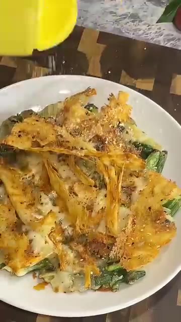 완성된 치즈 치지미 위에 파마산 치즈 가루와 파슬리를 뿌려 마무리한다. — 치즈 치지미
