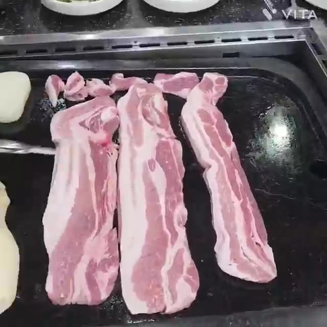 고기가 노릇하게 익으면 묵은지와 함께 쌈을 싸서 먹는다. — 돌판에 구워 먹는 삼겹살과 시래기 된장찌개