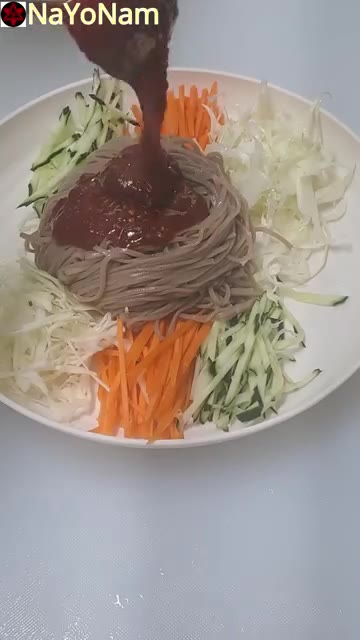 넓은 그릇에 메밀면을 담고 채 썬 오이, 당근, 양배추를 보기 좋게… — 매콤달콤 비빔막국수 만들기