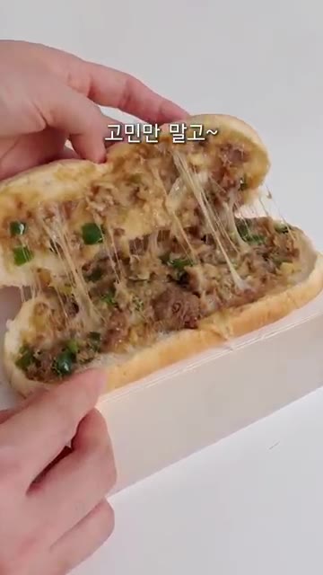 속이 꽉 찬 피타브레드를 먹기 좋게 반으로 접는다. — 냉동 피타브레드 치즈 듬뿍 간식