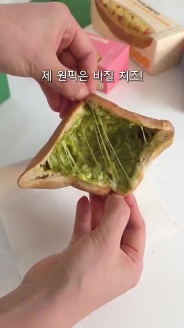 치즈가 쭉 늘어나는 바질 치즈 피타브레드를 보여준다. — 냉동 피타브레드 치즈 듬뿍 간식
