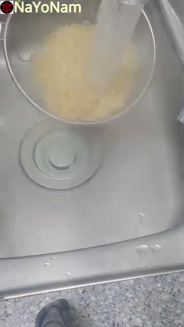 익힌 라면 사리를 체에 밭쳐 물기를 뺀다. — 매콤한 불닭 비빔면 레시피