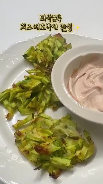 구워진 치즈 애호박전을 소스와 함께 접시에 담아냅니다. — 애호박 이렇게 먹어보세요🥒 바삭쫀득 치즈 애호박전