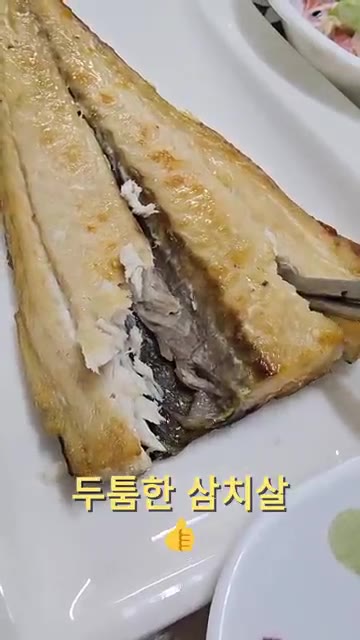 구운 생선살을 발라내어 고소한 맛을 즐긴다. — 집밥 한상차림: 돼지김치찜, 생선구이, 쌈채소 등