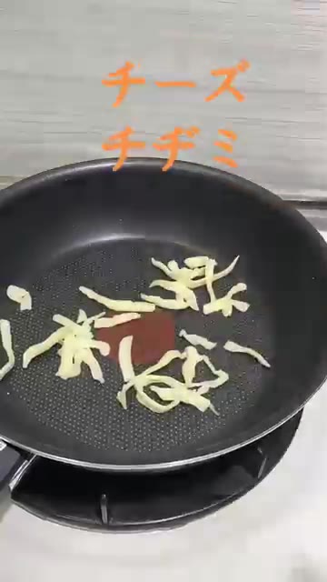 부추전을 뒤집고 치즈를 뿌린 후 녹을 때까지 익힌다. — 해물 치즈 부추전