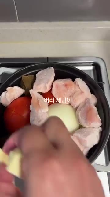 냄비에 토마토와 양파를 넣고 카레 조각과 닭가슴살, 버터를 올린다. — 여름 집밥: 토마토 무수분 카레