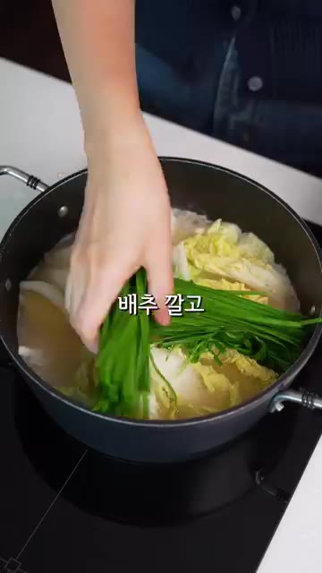 육수에 배추를 깔고 부추와 팽이버섯을 올린 뒤 배추보쌈을 넣는다. — 애들도 먹고 반한 삼겹살 배추말이 전골 레시피