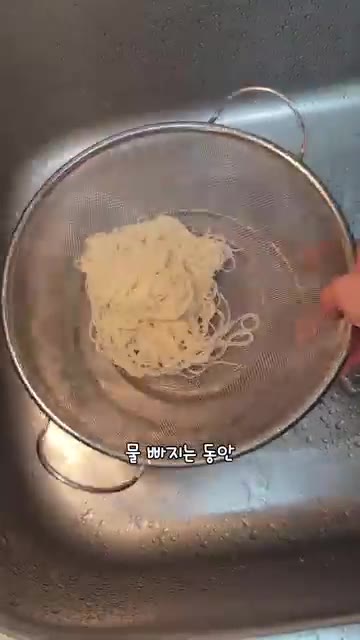 물기가 빠지는 동안 만두를 굽고 계란 프라이를 한다. — 절대 실패 없는 초간단 비빔국수 레시피